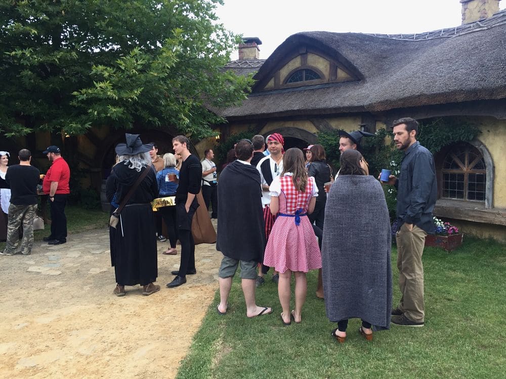 Hobbiton Green Dragon Inn - Guests of corporate staff party enjoying drinks close to outdoor fire