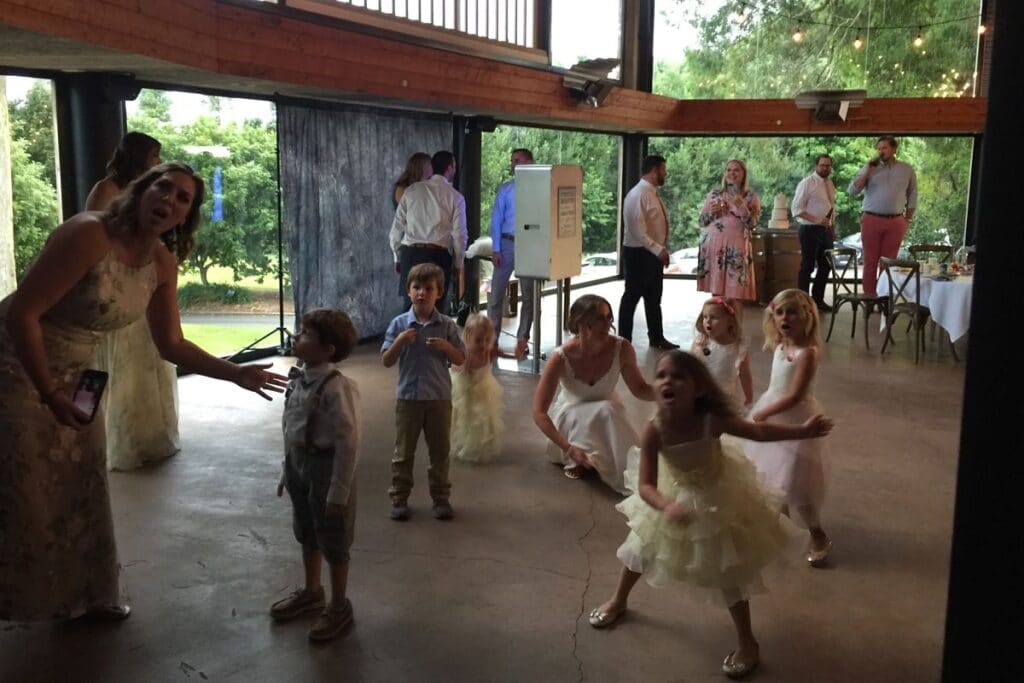 young children dancing and enjoying the photo booth in the Pirongia Deck at The Narrows Landing