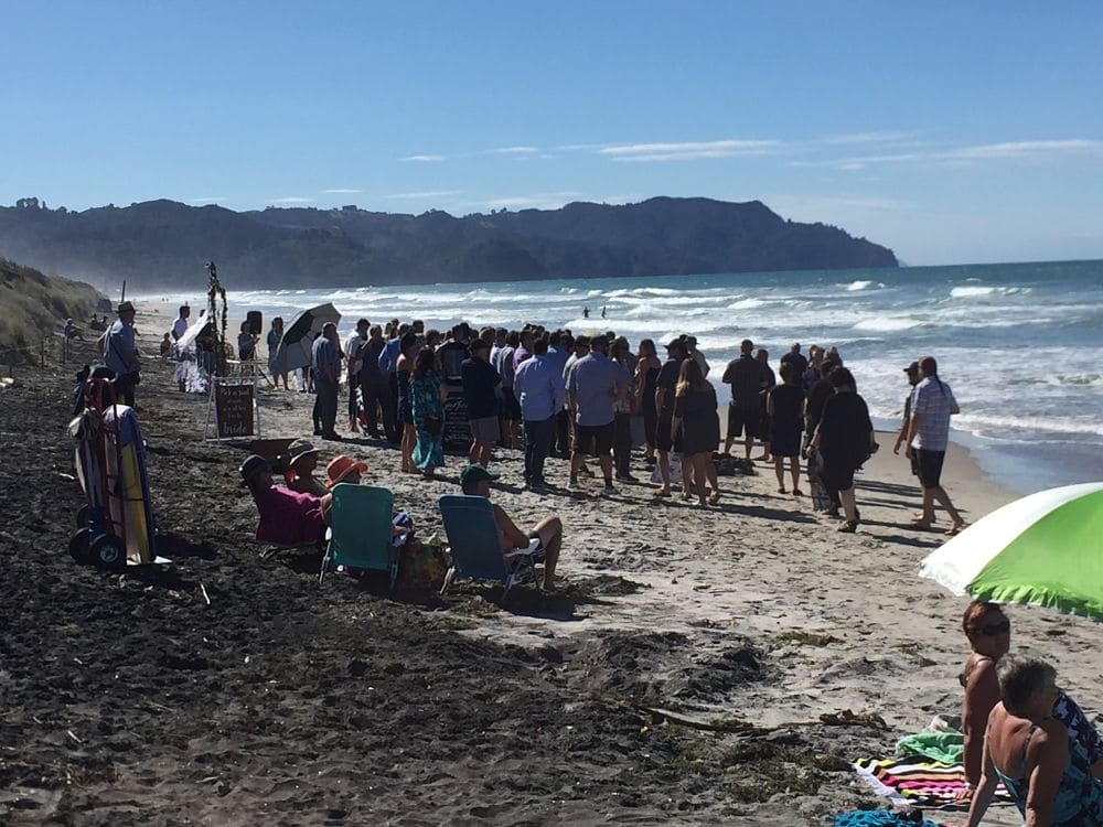 Wedding guests and beach goers enjoying sun and sand before wedding ceremony
