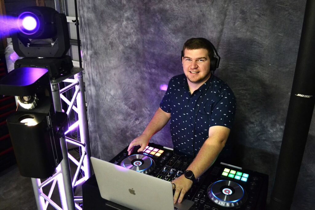 DJ Brady from Sounzgood DJ Entertainment Smiling at camera above DJ booth