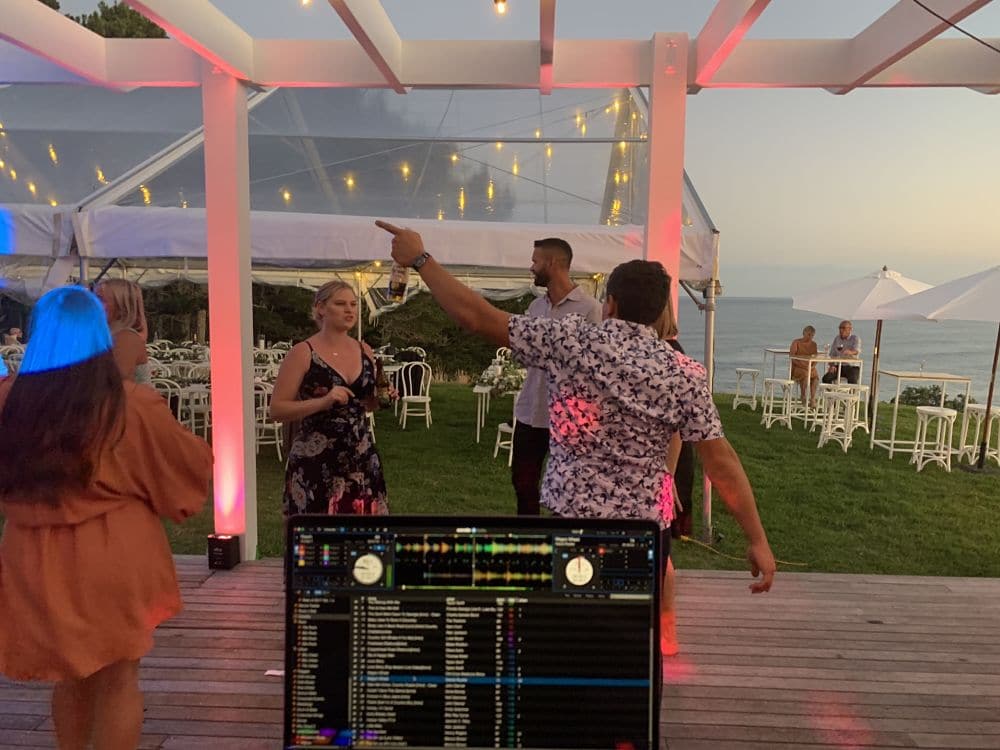 Orua Beach House - Wedding guests dancing next to DJ and his up lights