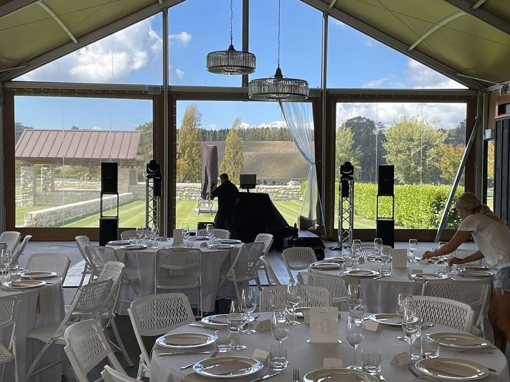 Takapoto Estate - DJ setting up speakers and lighting for wedding in the gold marquee