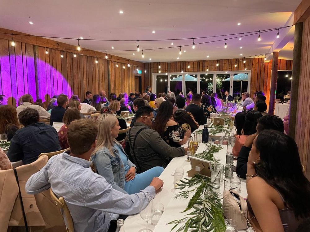 Wedding guests seated during dinner and speeches at The Black Barn - Tarawera Lake - Rotorua