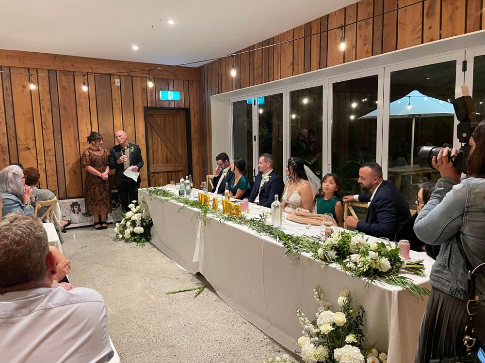 Bridal table with wedding party seated during speeches at The Black Barn - Tarawera Lake - Rotorua